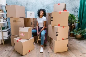 A girl sitting in a chair surrounded by cardboard boxes